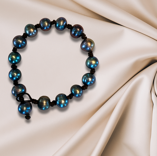 Peacock freshwater pearl bracelet, double-knotted on Greek leather for an organic feel.