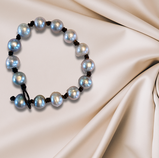 Gray freshwater pearl bracelet, double-knotted on Greek leather, offering understated elegance.